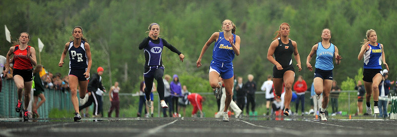 Katie Hall, center, of Lake Region storms to the finish to win the 100 in a Class B record 12.33 seconds. Hall, a freshman, also captured the 200 and the long jump at the Class B state meet.
