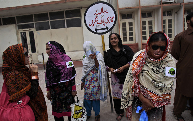 Pakistani Allah Rakhi, 51, third from left, whose nose was sliced off by her husband, stands with acid-attack survivors outside a hospital in Rawalpindi on May 20.