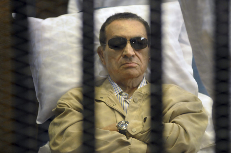 Egypt’s former President Hosni Mubarak lies on a gurney inside a barred cage at a courthouse in Cairo on Saturday.
