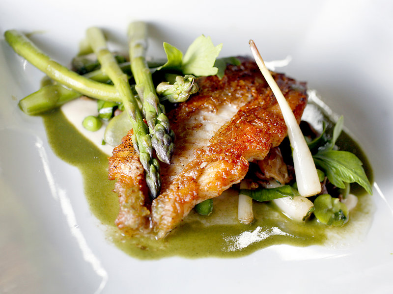 Pan-roasted red fish with spring vegetable fricassee and asparagus veloute, at Grace in Portland.