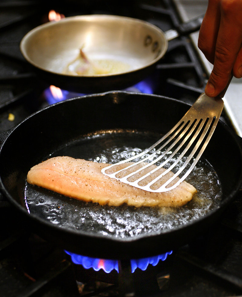 Executive chef Peter Sueltenfuss of Grace prepares his pan-roasted red fish.