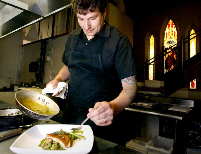 In the kitchen at Grace in Portland, executive chef Peter Sueltenfuss prepares and plates a serving of his pan-roasted red fish with spring vegetable fricassee and asparagus veloute. Grace is among 20 Maine restaurants participating in Out of the Blue, organized by the Gulf of Maine Research Institute.
