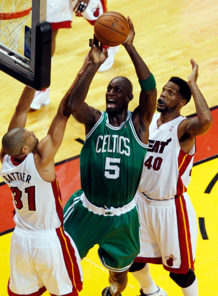 Kevin Garnett, a force Tuesday night for the Boston Celtics with 26 points and 11 rebounds, drives against Shane Battier, left, and Udonis Haslem of the Miami Heat.