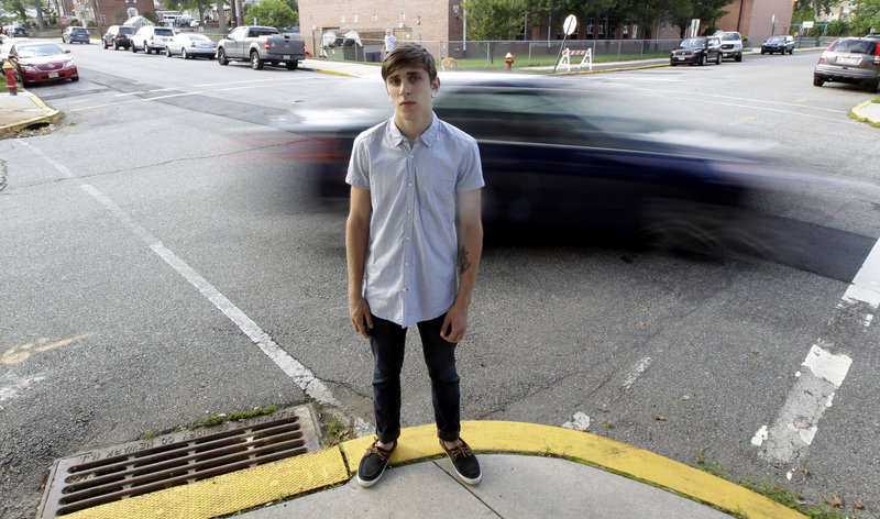 A vehicle cruises by Dylan Young, 18, in North Arlington, N.J., this week. Young, a high school senior, was in a minor accident caused by being distracted while texting and driving. He said it taught him “to be a lot more cautious,” but he admitted he sometimes still texts behind the wheel. “Nothing seems to stop them. It’s ridiculous,” his mother said.