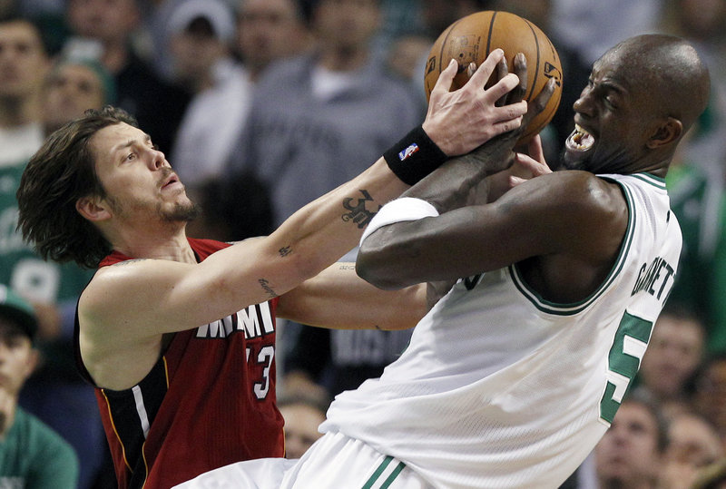 Kevin Garnett of the Boston Celtics, right, tries to keep a rebound from Mike Miller of the Miami Heat during Miami’s 98-79 victory Thursday night.