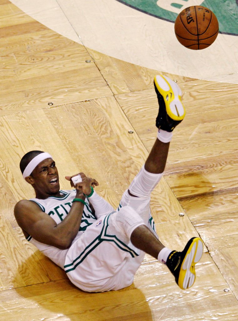 The ball goes one way, Rajon Rondo of the Celtics goes the other after a collision with Mario Chalmers of the Miami Heat.