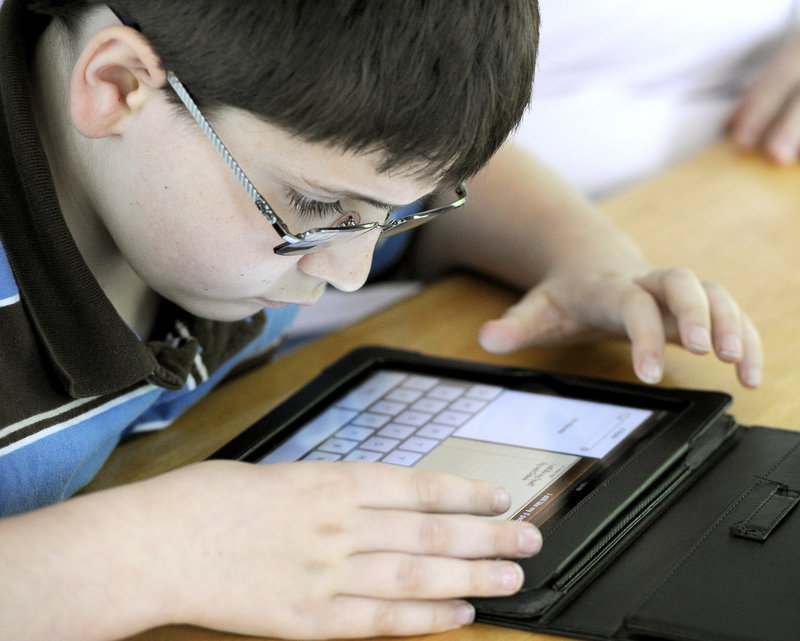 Zackery Dubois, 10, studies spelling on the iPad he received from the Robbie Foundation to help with his schooling.