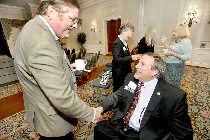 Attorney General William Schneider, right, a candidate for the GOP nomination for the U.S. Senate, greets Chris Hall at a forum last month. Schneider’s political convictions and record in public service “distinguish him as a leader,” a reader says.
