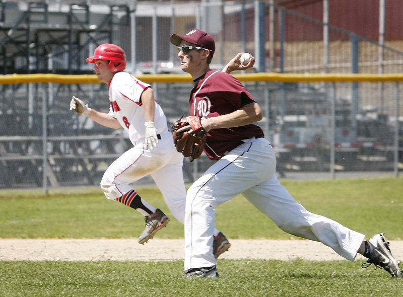 Windham pitcher Nate Boyle throws home for an out while Scarborough's Aaron Ravin heads to third base during their Western Class A semifinal Saturday. Scarborough avenged two regular-season losses to the Eagles, winning 7-0 to advance to the regional final against Cheverus.