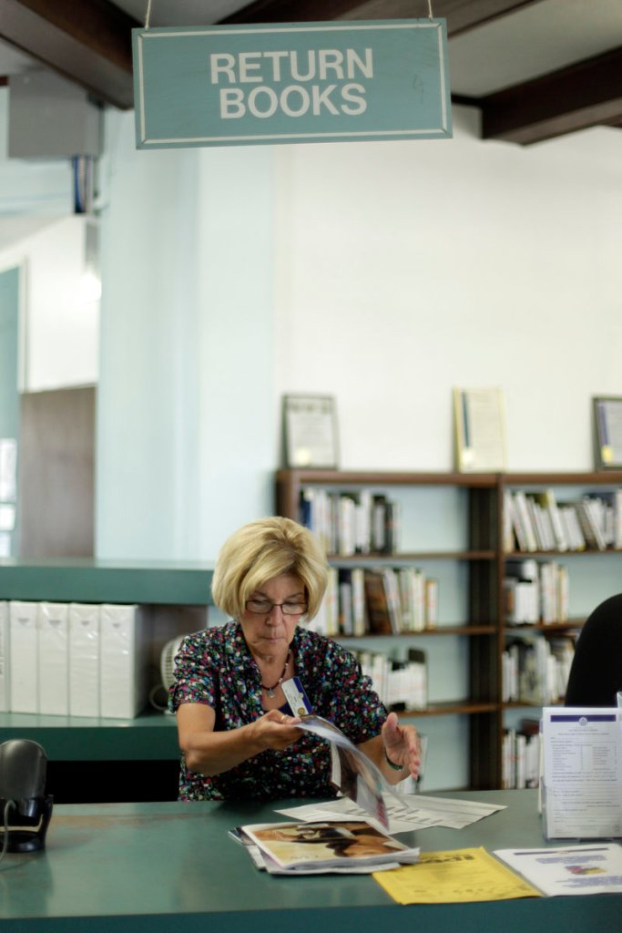 Library clerk Jane Stahl organizes items at a branch of the San Diego, Calif., Public Library. The city’s pension-fund payments soared to $231 million this year, leaving less money for services like the libraries.