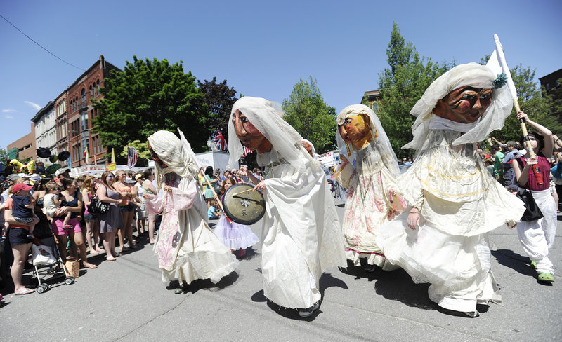 Performers with Shoestring Theater make their way down Exchange Street during the parade at the Old Port Festival in Portland on Sunday. Thousands of people filled the city to listen to music, watch street performers and check out the vendors.