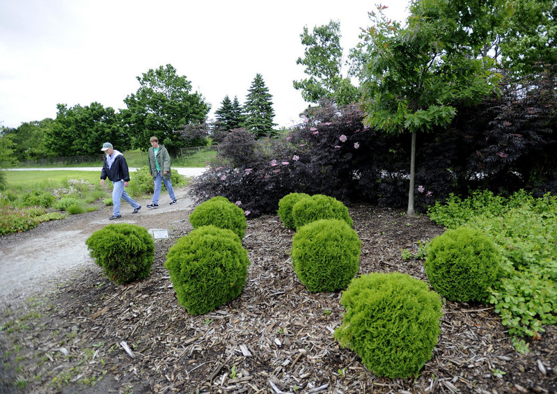 Wayne Wilson, left, of Old Orchard Beach and Eric Cushing of Scarborough walk through the YardScaping Gardens at Back Cove on Tuesday.