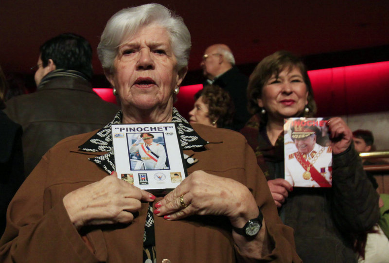 Supporters hold pictures of Pinochet at the screening of a pro-Pinochet documentary Sunday. Loyalists say Pinochet saved Chile from communism and was a victim of vengeful leftists who accused him of human rights abuses.