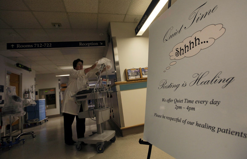 A sign is posted for “quiet time” while Nursing Director Theresa Capodilupo works under dimmed lighting in the hall of the Surgical Trauma Unit at Massachusetts General Hospital in Boston on Friday.