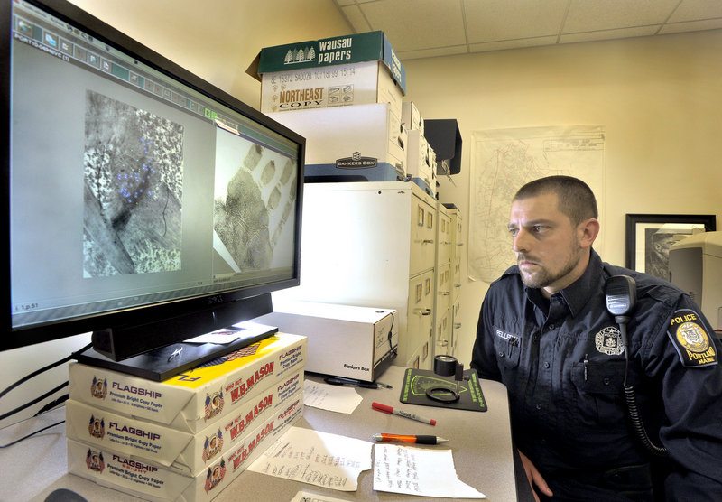 Portland Police Department evidence technician Frank Pellerin examines a palm print on his computer monitor.