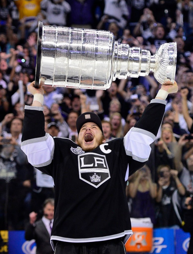 Kings captain Dustin Brown hoists the Stanley Cup after his team’s 6-1 win Monday against New Jersey.