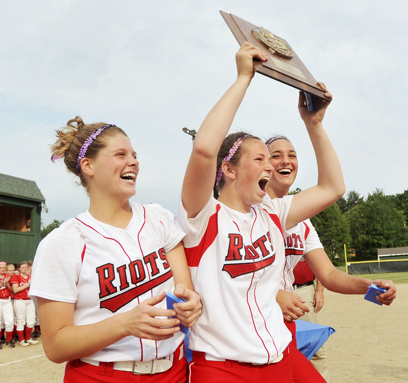 Danica Gleason, center, flanked by Libby Grant, left, and Erin Bogdanovich – the three captains for the South Portland softball team – raises the plaque Tuesday after the Red Riots won the Western Class A softball title with a 5-1 victory against Scarborough.