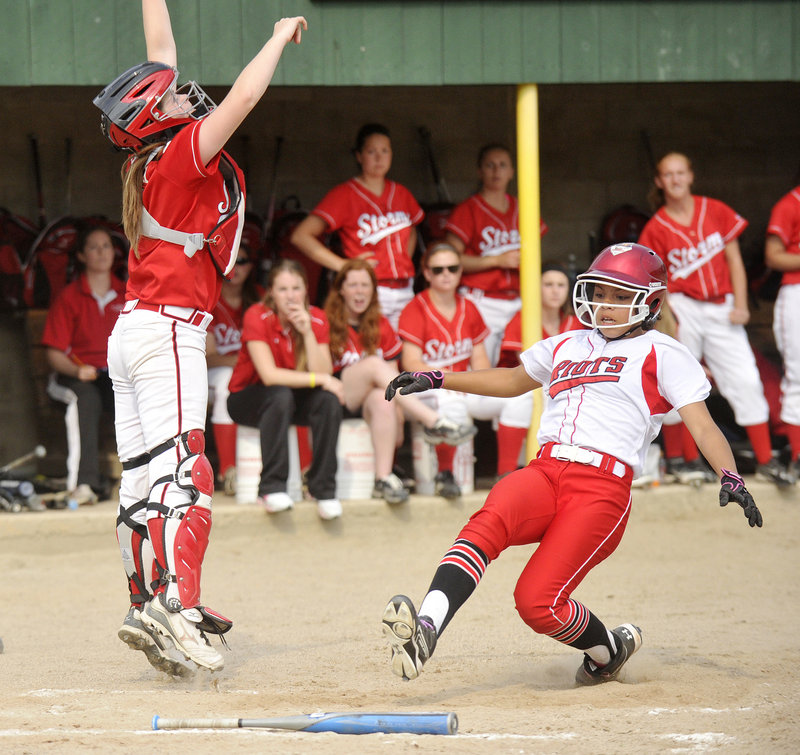 Laurine German of South Portland ties the game, scoring on a single by Olivia Indorf – the first run of a five-run sixth inning that gave the Red Riots a 5-1 victory in the Western Class A final Tuesday. The Scarborough catcher is Abbie Sweatt.