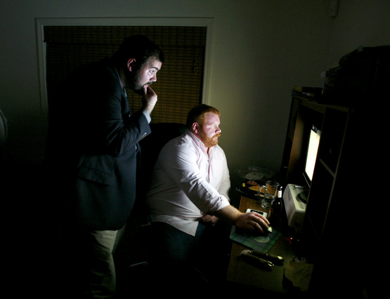 Patrick Calder, left, and his deputy campaign manager, Andrew Love, monitor the neck-and-neck election results Tuesday night on a computer at Calder’s home in Portland.