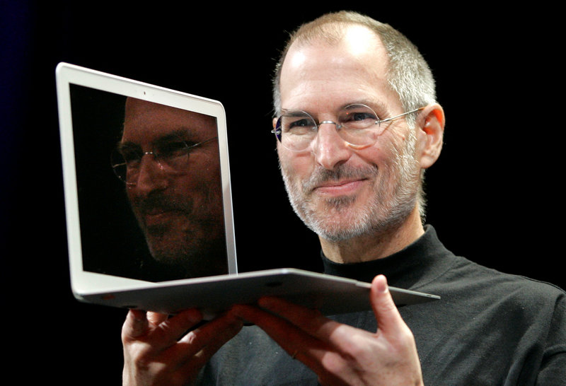 In this 2008 photo, Apple CEO Steve Jobs holds up the new MacBook Air after giving the keynote address at the Apple MacWorld Conference in San Francisco.