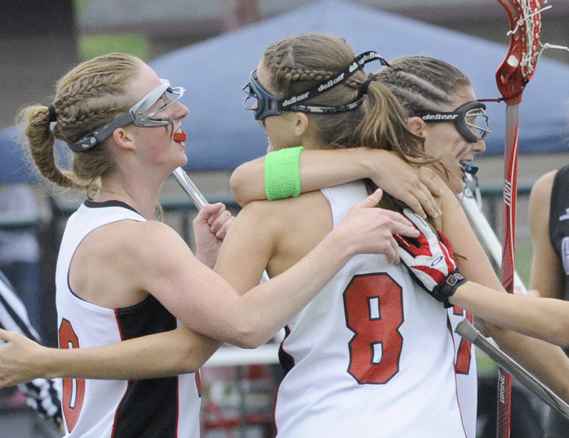 Avery Pietras, No. 8, is congratulated by Maggie Smith, left, and Sarah Martens after scoring the third goal of Scarborough’s 13-3 victory against Marshwood.