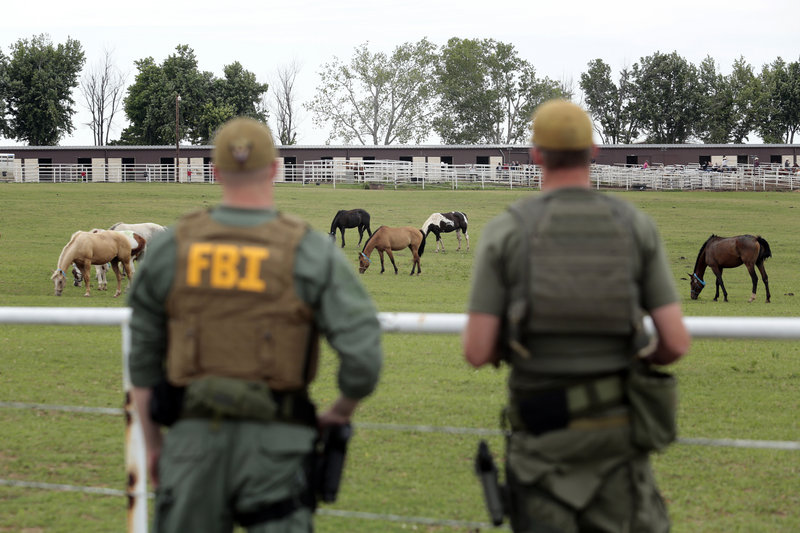 FBI agents overlook a horse ranch under investigation Tuesday in Lexington, Okla. Federal agents raided the ranch Tuesday, alleging its owner was using the horse-breeding operation to launder drug money.