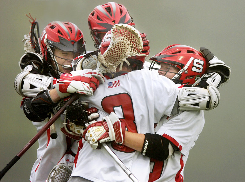John Wheeler, center front, celebrates with his teammates after scoring just before the end of the first half Wednesday night against Kennebunk in the Western Class A boys’ lacrosse championship game. Wheeler finished with three goals and an assist as Scarborough won, 6-3.
