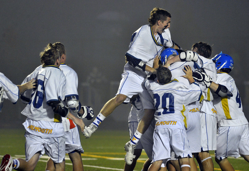 Falmouth goalie Cam Bell jumps over his teammates and into the pile Wednesday night after the Yachtsmen defeated Cape Elizabeth 10-9 to repeat as the Western Class B schoolboy lacrosse champions.