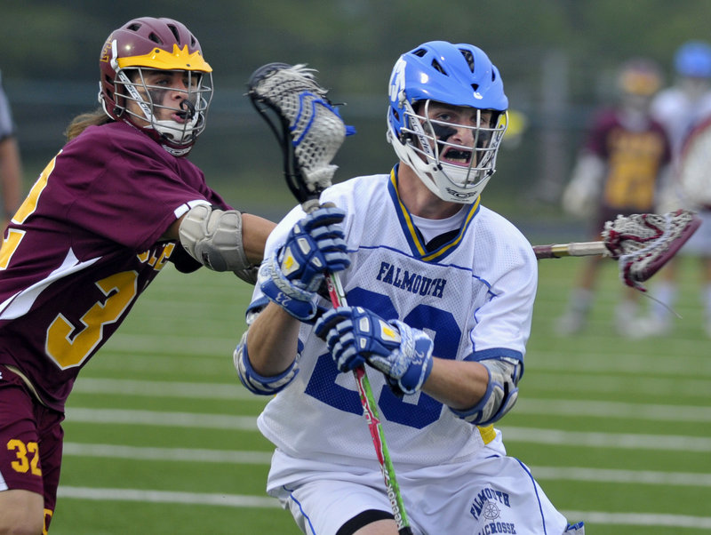 Jack Cooleen of Falmouth prepares to pass while taking a hit from Adam Haversat of Cape Elizabeth during Falmouth’s 10-9 victory in the Western Class B final Wednesday night.