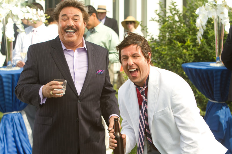 Tony Orlando, left, plays the rich, crude and self-indulgent boss of the son of slacker Adam Sandler, right, in a scene from the movie “That’s My Boy.”
