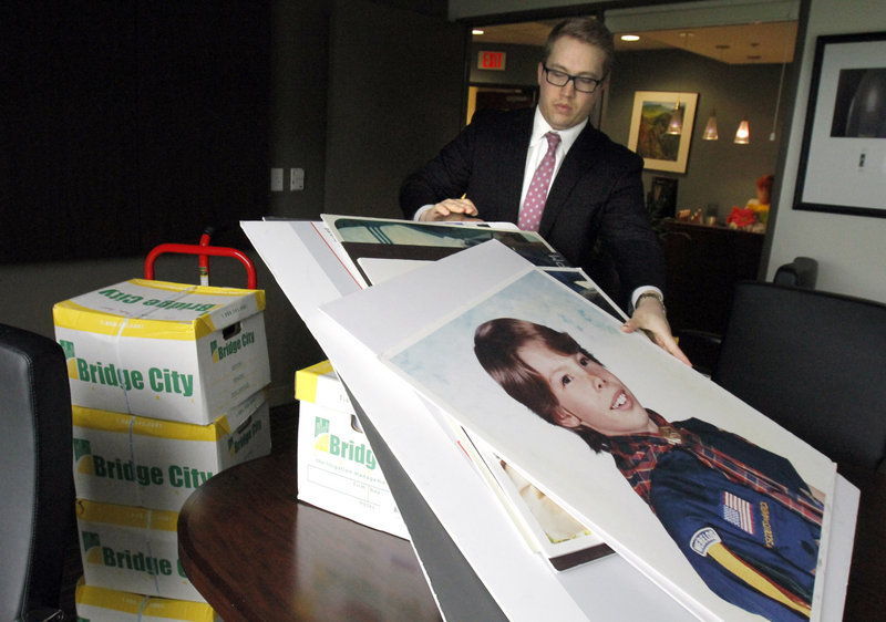 Attorney Peter Janci sets court case displays upon boxes full of records from the Boy Scouts of America in Portland, Ore. The state Supreme Court ordered their release Thursday.