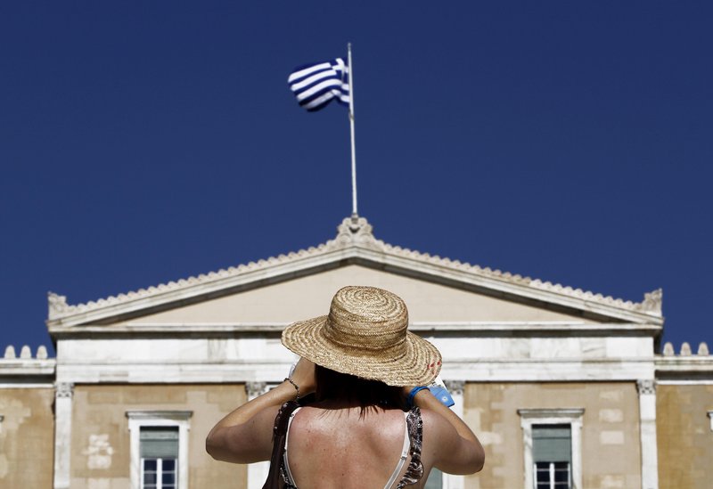 A tourist takes photos of the Greek Parliament in central Athens. A Greek election Sunday will go a long way toward determining whether the country continues to use the euro.