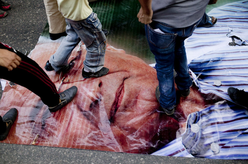 Egyptian demonstrators step on a depiction of presidential candidate Ahmed Shafiq on Friday in Cairo. Shafiq is widely believed to be an extension of Hosni Mubarak’s regime.