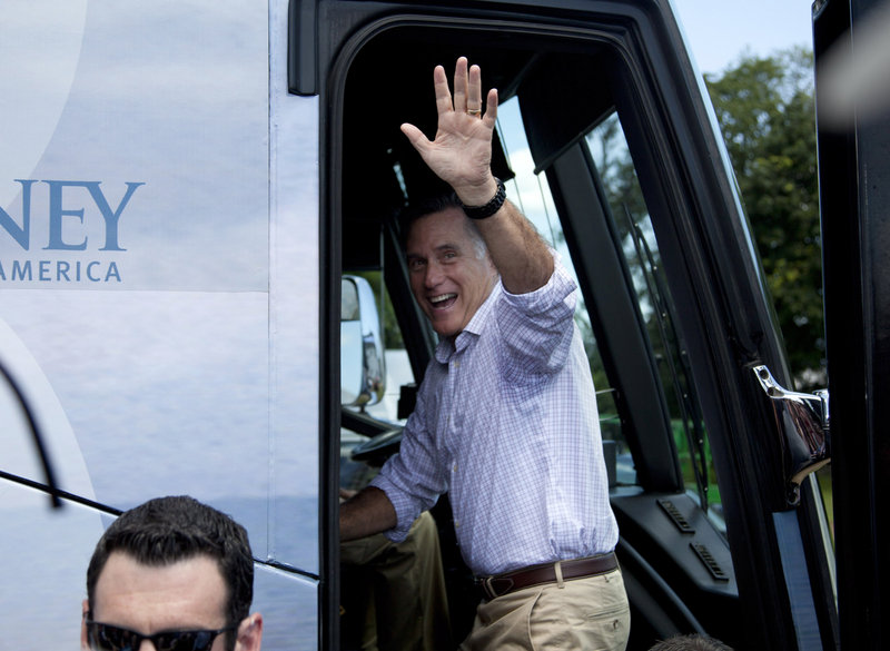 Mitt Romney waves as he gets on his bus after a stop at the Scamman Farm in Stratham, N.H., Friday.
