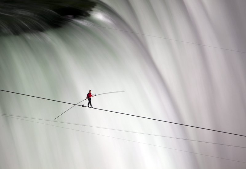 Nik Wallenda walks over Niagara Falls on a tightrope Friday, becoming the first person to do so. ABC television, a sponsor of the event, insisted he wear a safety tether.