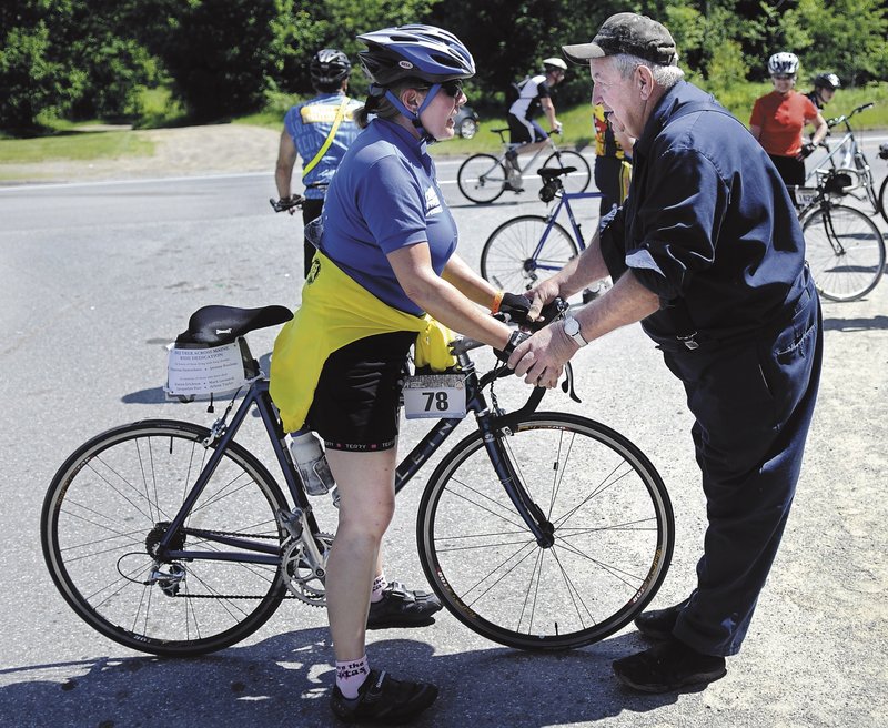 Volunteer Leo Smith helps Kris Ebbeson of Rochester, N.H., keep her balance Sunday after she climbed a hill on Route 3 in Palermo. The trek benefits the American Lung Association.