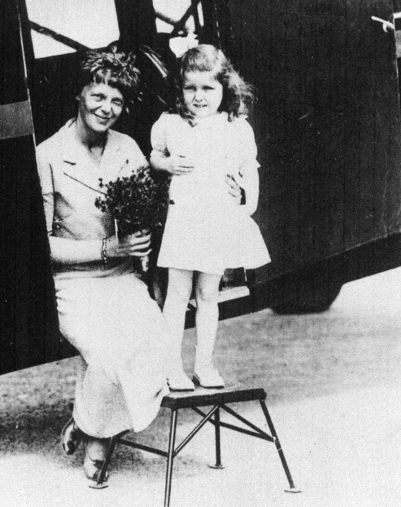 Amelia Earhart gets flowers from Gladys Chase, age 5, of Augusta on Aug. 14, 1934, at the Augusta airport.