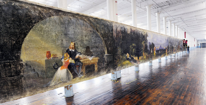 A section of the 800-foot muslin scroll “Moving Panorama of Pilgrim’s Progress” goes up in the cavernous former loom room at the Pepperell Mill complex in Biddeford.