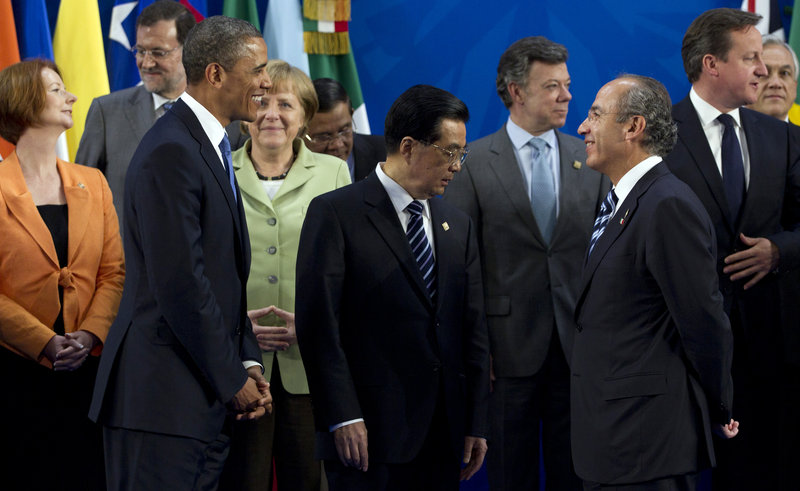 President Obama looks to Mexican President Felipe Calderon as he joins other leaders at the G20 Summit on Monday in Los Cabos, Mexico. They are, from left, Australian Prime Minister Julia Gillard, Spanish Prime Minister Mariano Rajoy, German Chancellor Angela Merkel, Chinese President Hu Jintao, Colombian President Juan Manuel Santos, Calderon and British Prime Minister David Cameron.
