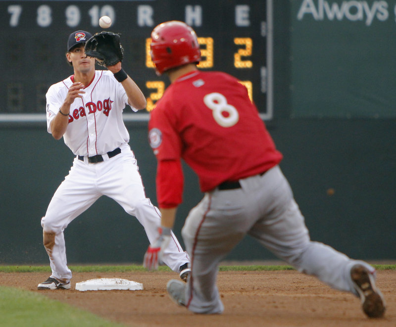 Derrik Gibson of the Portland Sea Dogs takes a toss ahead of Sean Nicol of Harrisburg before throwing to first for a double play Tuesday night during a 14-0 victory at Hadlock Field.