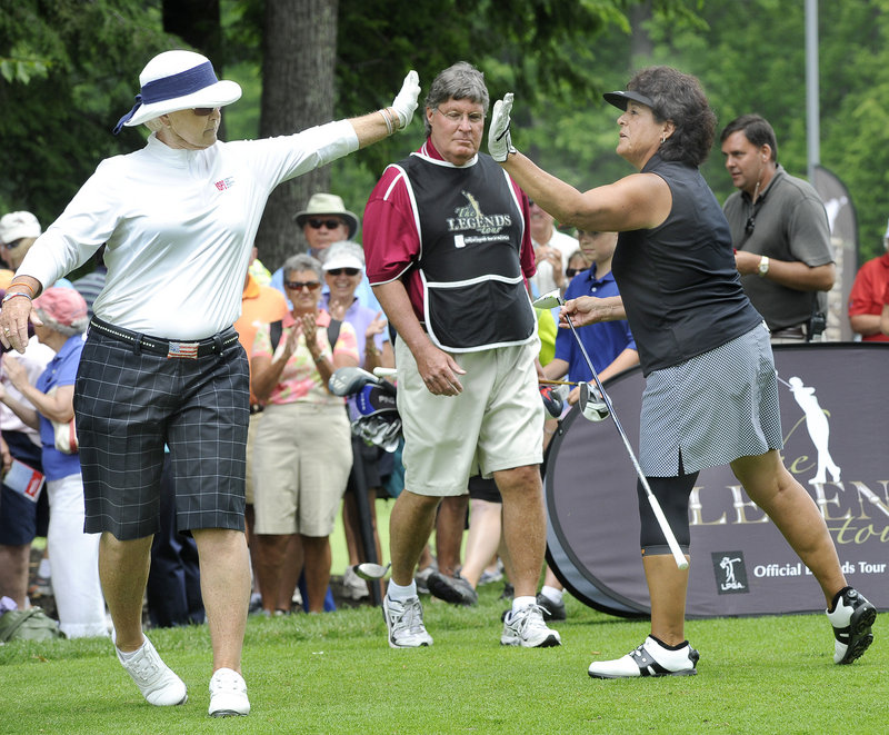 Pat Bradley, left, exchanges a high-five with Nancy Lopez. The two Hall of Famers drew the largest gallery but turned in disappointing first-round scores.