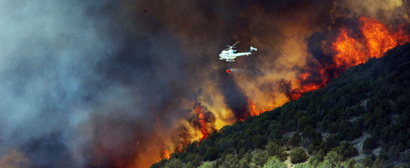 Emergency responders attempt to control a wildfire that is threatening homes in Saratoga Springs, Utah, on Friday.