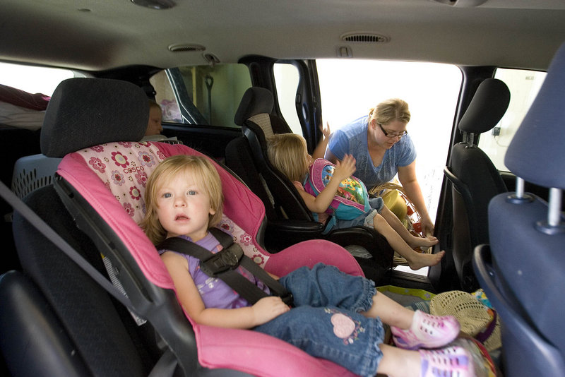 Luci Christiansen, 2, waits for her mother, Lisel, to finish loading their van as they prepare to leave their home in Eagle Mountain, Utah, on Friday.