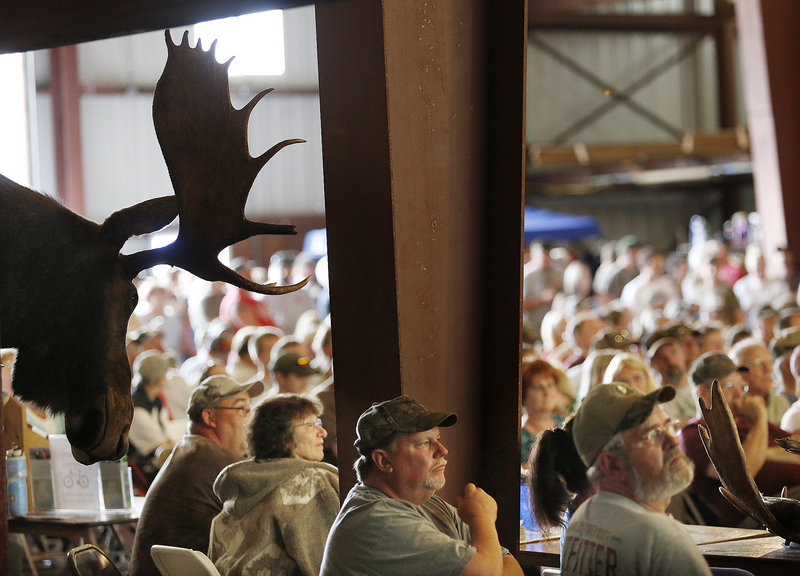 People listen for their names to be called during the moose lottery in Oquossoc on Saturday. Officials said it was the biggest festival ever held in the region.