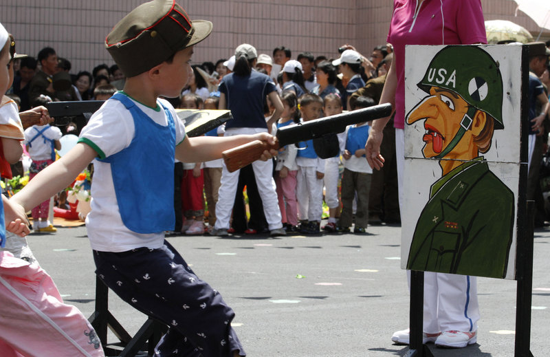A student points a toy gun at a painting of a U.S. soldier during a game on the grounds of Kyongsang Kindergarten in Pyongyang, North Korea, as the country marked International Children's Day on June 1. For North Korean children, the systematic indoctrination of anti-Americanism starts as early as kindergarten, and is as much a part of the curriculum as learning to count.