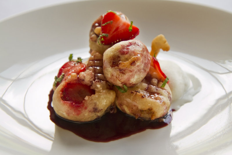 Chef Carmen Gonzales is celebrating the season with a dessert of strawberry and banana fritters, above, served with vanilla bean ice cream and a red wine sauce. Local farmers say the crop is peaking early.
