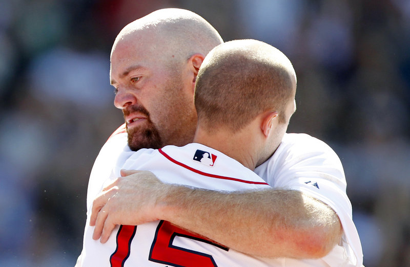 Kevin Youkilis embraces Dustin Pedroia as he leaves Sunday’s game against the Atlanta Braves. The Red Sox announced after the game that Youkilis had been traded to the White Sox.