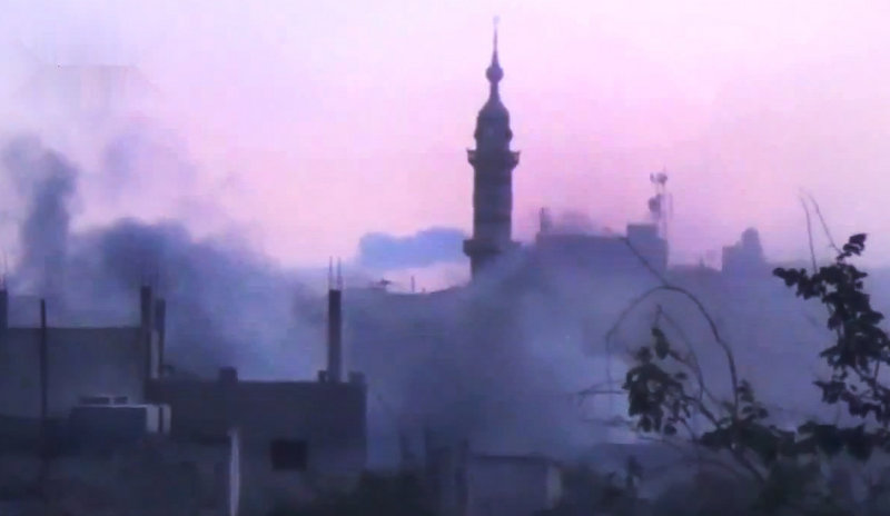 In this image made from amateur video released by the Shaam News Network and accessed Monday, smoke rises from buildings following purported shelling in Homs, Syria. On Monday, the Red Cross said hundreds of civilians are trapped in Homs and aid workers cannot reach them.