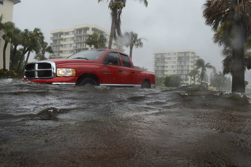 A motorist drives through a flooded road near Siesta Key Public Beach on Monday after rain from Tropical Storm Debby filled streets with water on the Sarasota, Fla., barrier island.