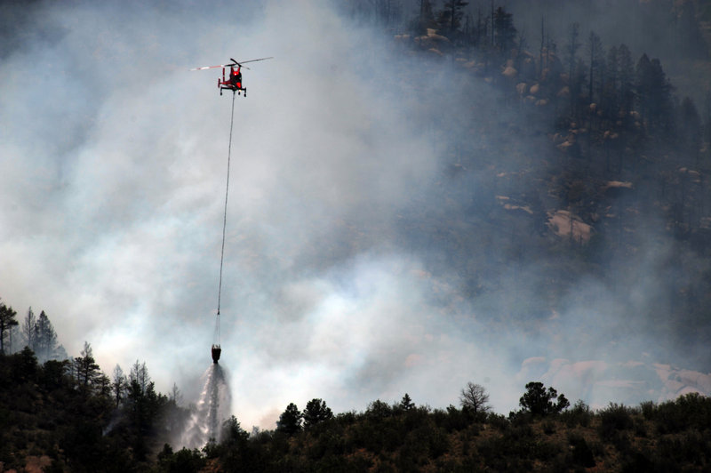 A firefighting helicopter makes a drop on the Waldo Canyon fire west of Colorado Springs, Colo., on Monday.